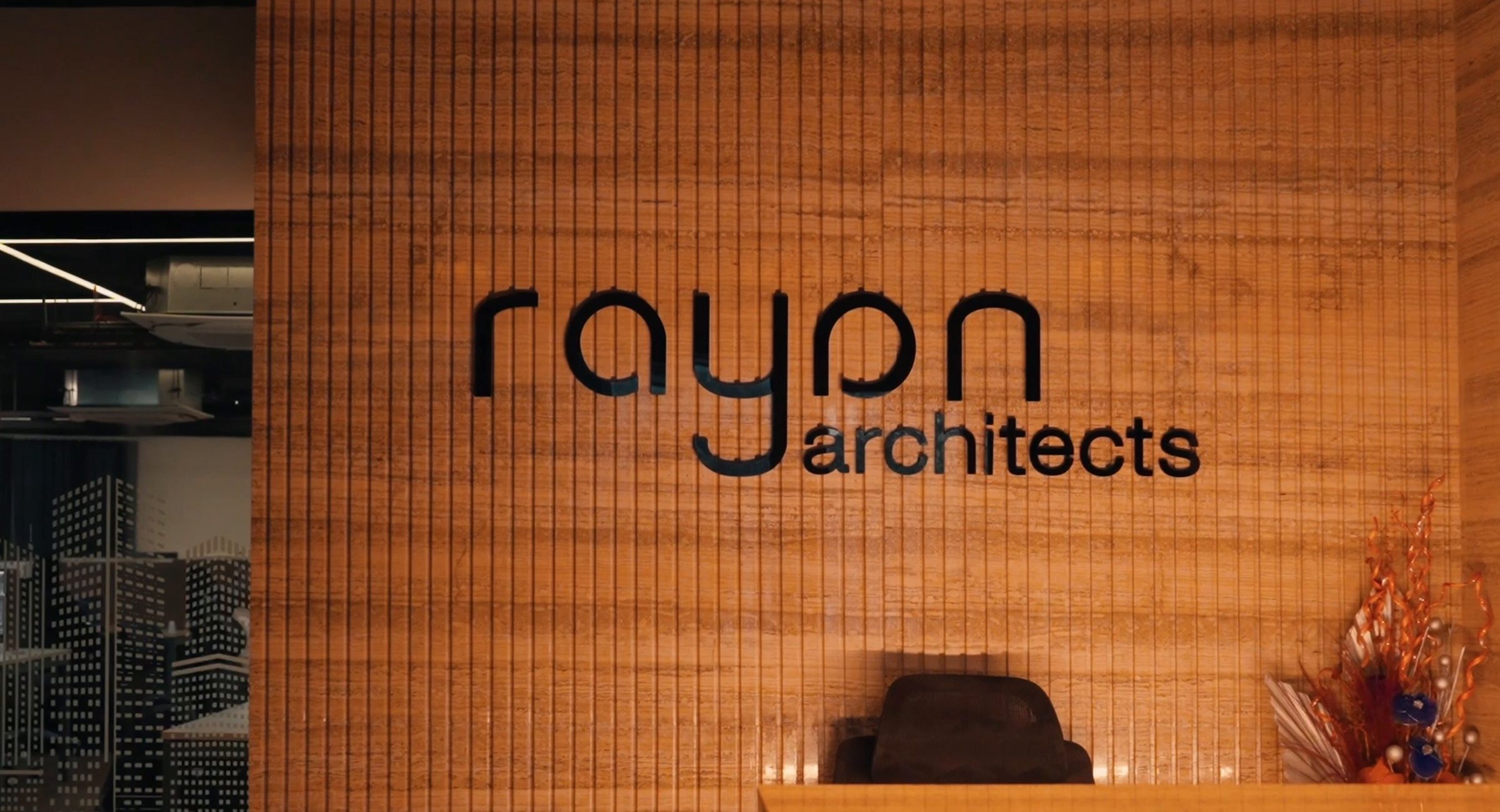 Still from the Rayan Architects studio film: the practice's wordmark on its reception wall